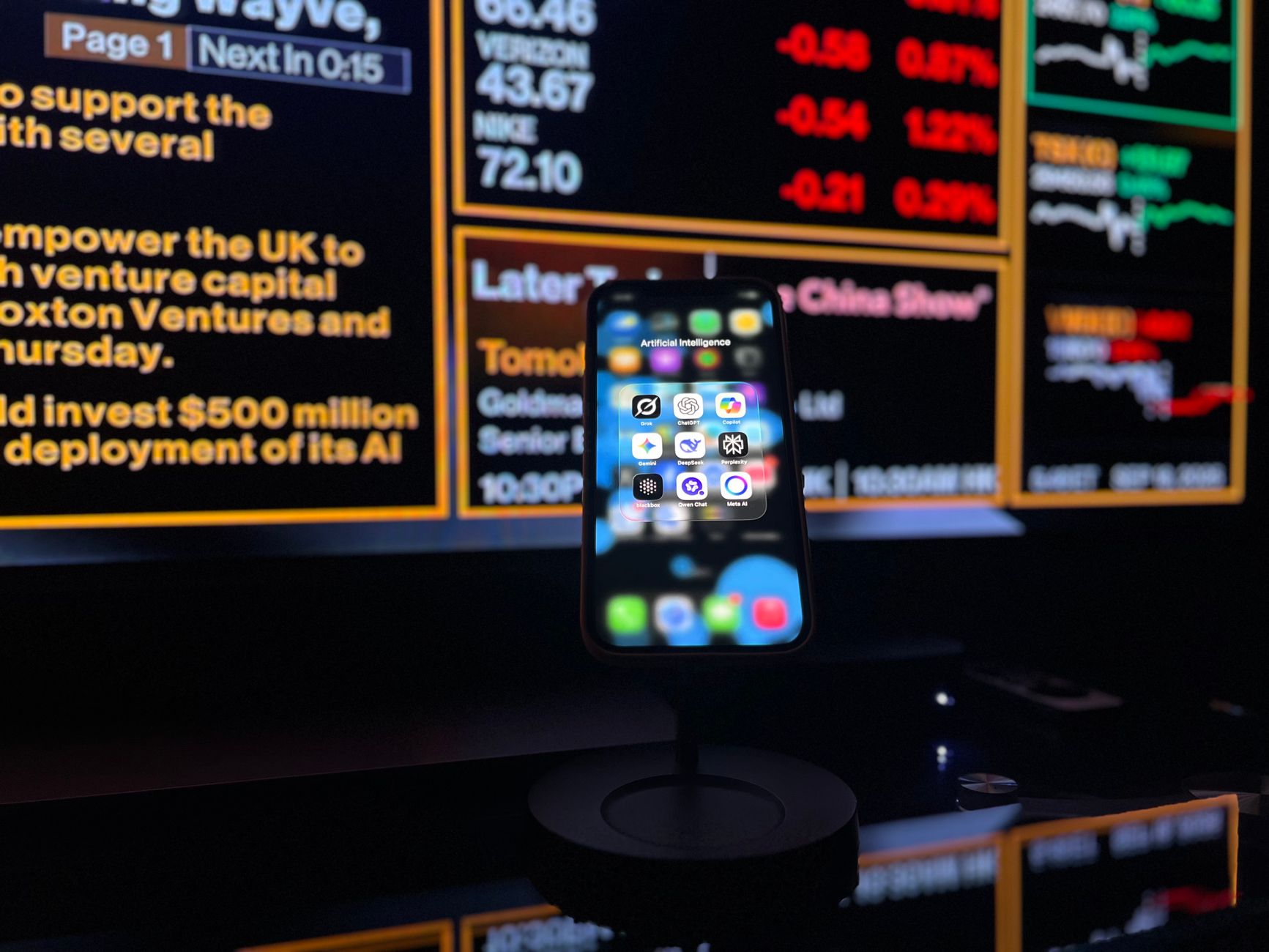 Smartphone com aplicativos de inteligência artificial diante de uma tela com dados financeiros.